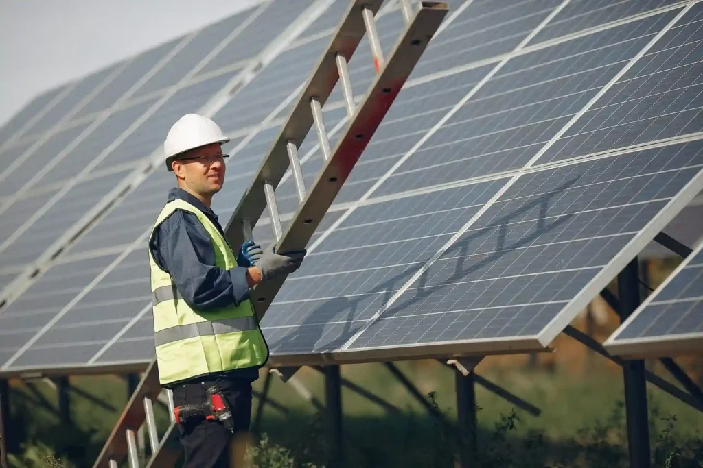 “Solar technician inspecting solar panels at a large solar power installation site”